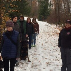 PrairieBurn K9 Academy ultimate shadow experience participants walking down a path with their dogs